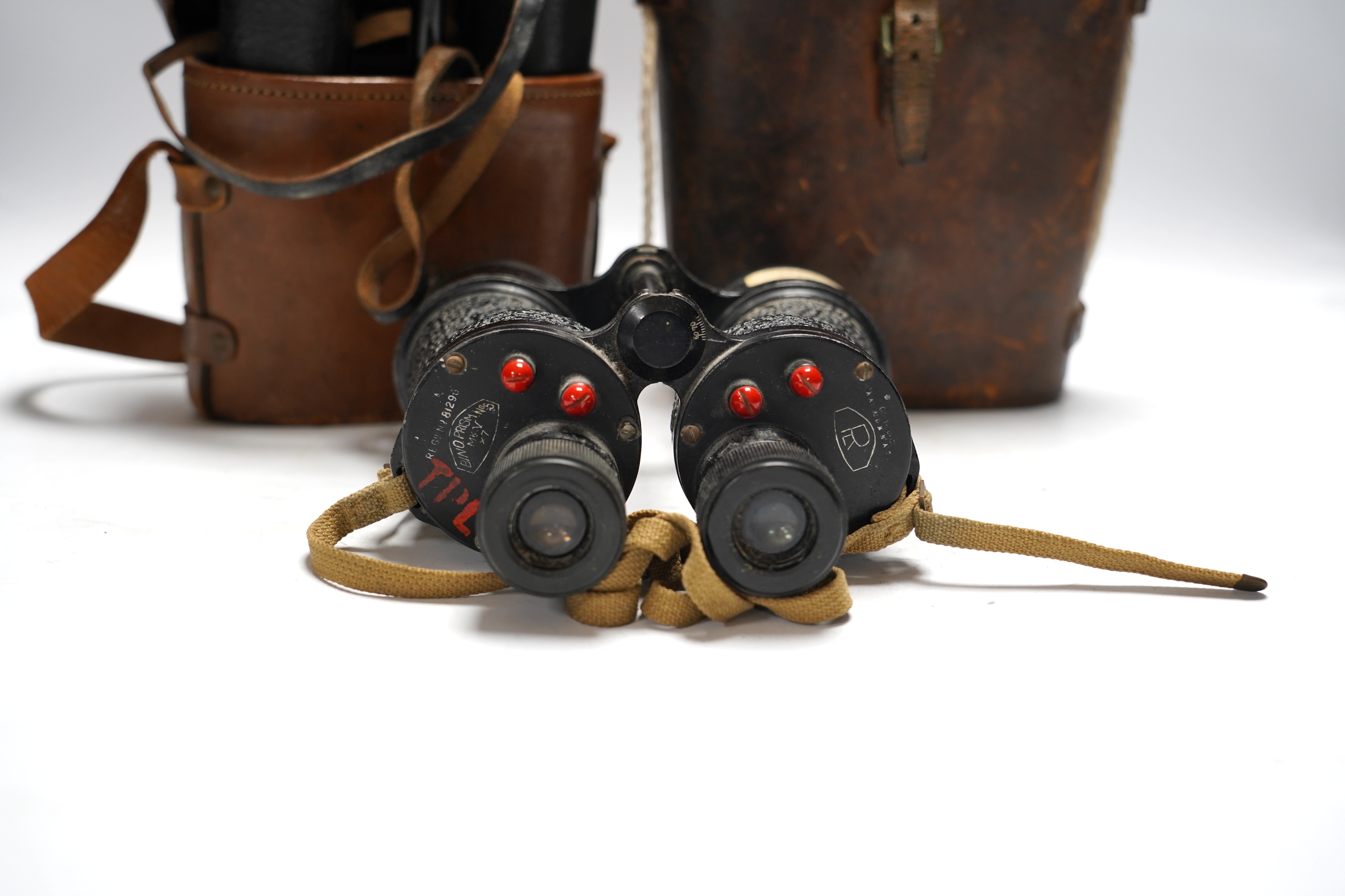 Two cased pairs of binoculars and a brass bugle.